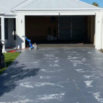Driveway resurfacing in Austin's Ferry: worn concrete driveway with cleaning equipment.